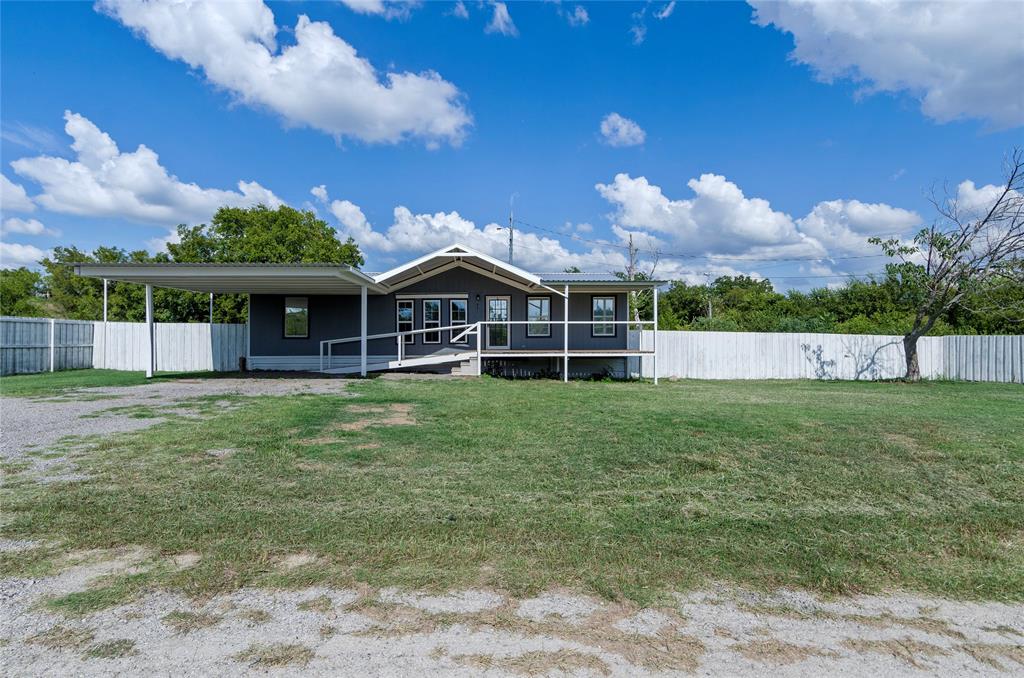 401 Barker Street Bowie, TX 76230 - Photo 3 of 24 a front view of a house with a garden