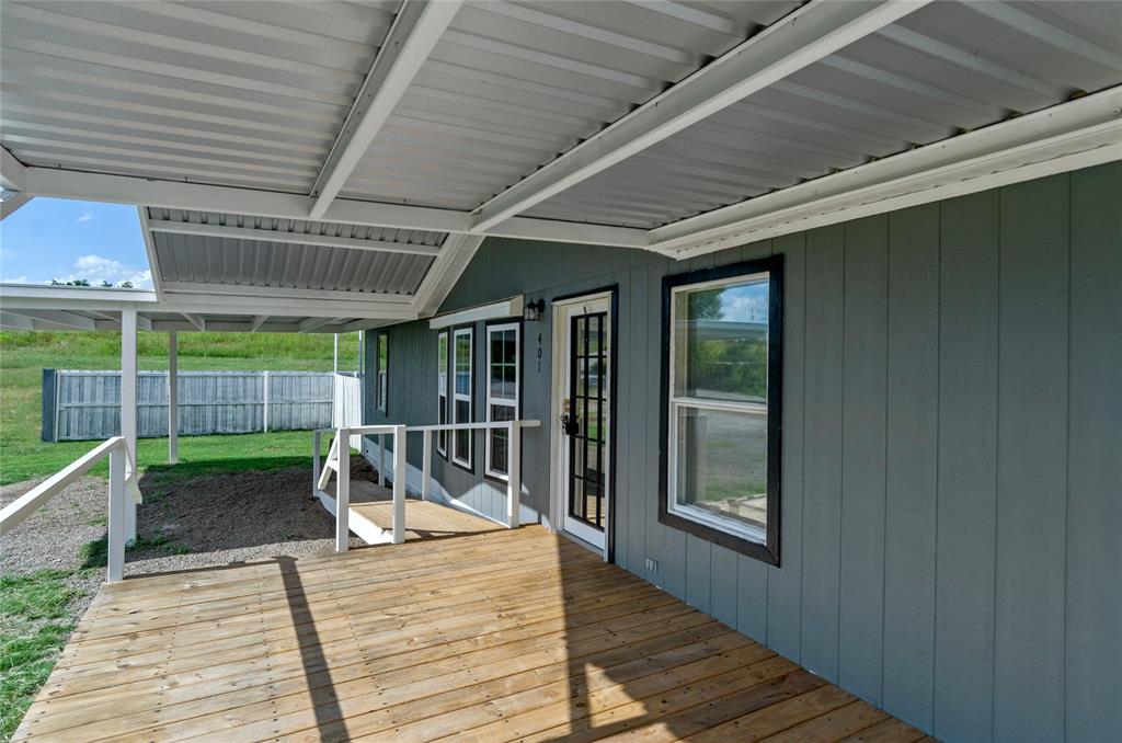 401 Barker Street Bowie, TX 76230 - Photo 4 of 24 a view of a porch with wooden floor and a potted plant