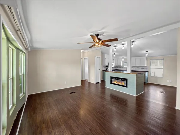 a kitchen with stainless steel appliances granite countertop a refrigerator a stove a sink dishwasher and a fireplace with wooden floor
