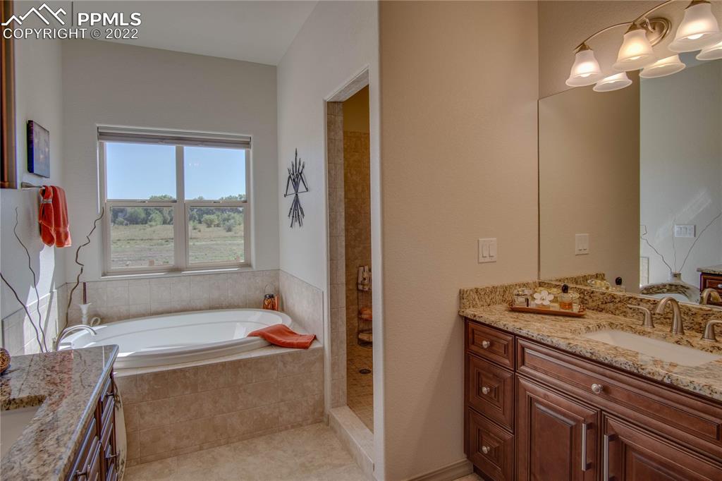 124 Rocchio Drive Florence, CO 81226 - Photo 23 of 34 a bathroom with a granite countertop tub sink and mirror