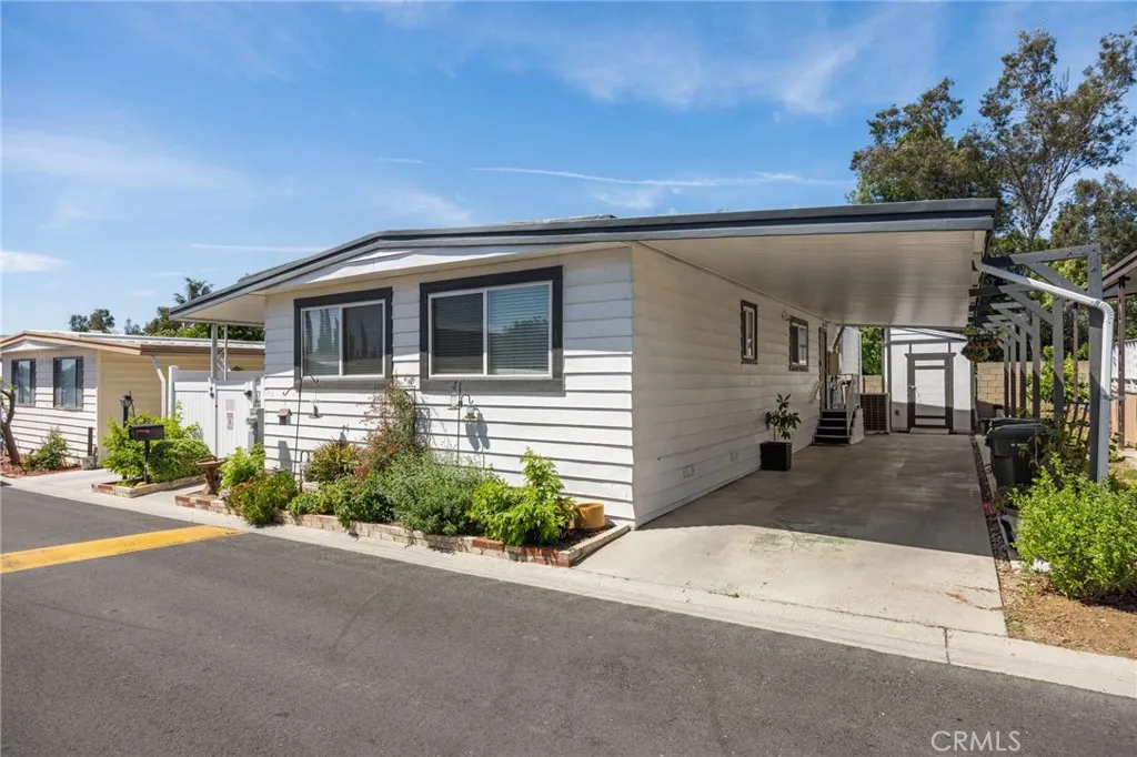 1051 Site, Unit 38 Brea, CA 92821 - Photo 2 of 45 a front view of a house with a yard and garage
