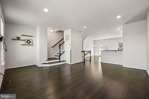 a view of an empty room with wooden floor and a cabinet
