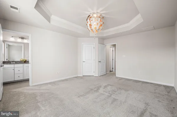 a view of an empty room and a chandelier fan