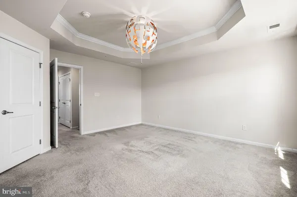 an empty room with chandelier fan