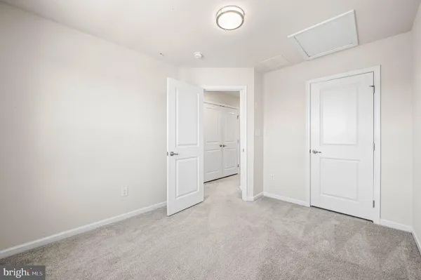 an empty room with white cabinet and mirror