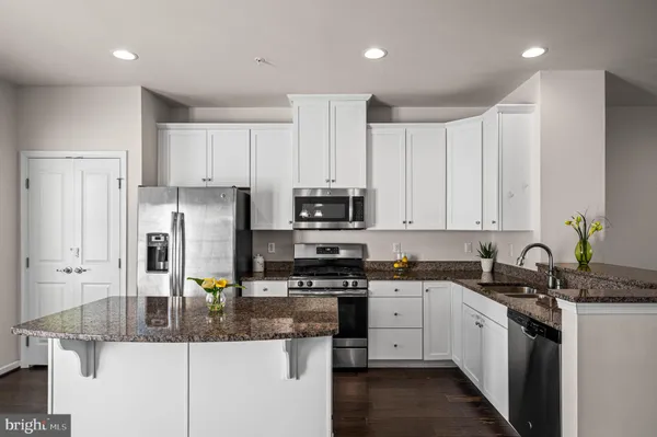 a kitchen with stainless steel appliances granite countertop a sink a stove and a refrigerator