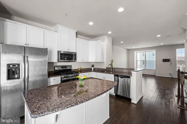 a kitchen with stainless steel appliances granite countertop a sink a stove top oven a counter space and cabinets