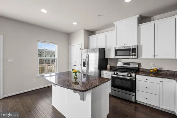 a kitchen with stainless steel appliances granite countertop a sink stove microwave and cabinets