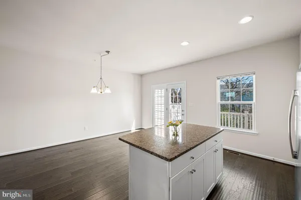 a kitchen with granite countertop a sink cabinets and wooden floor