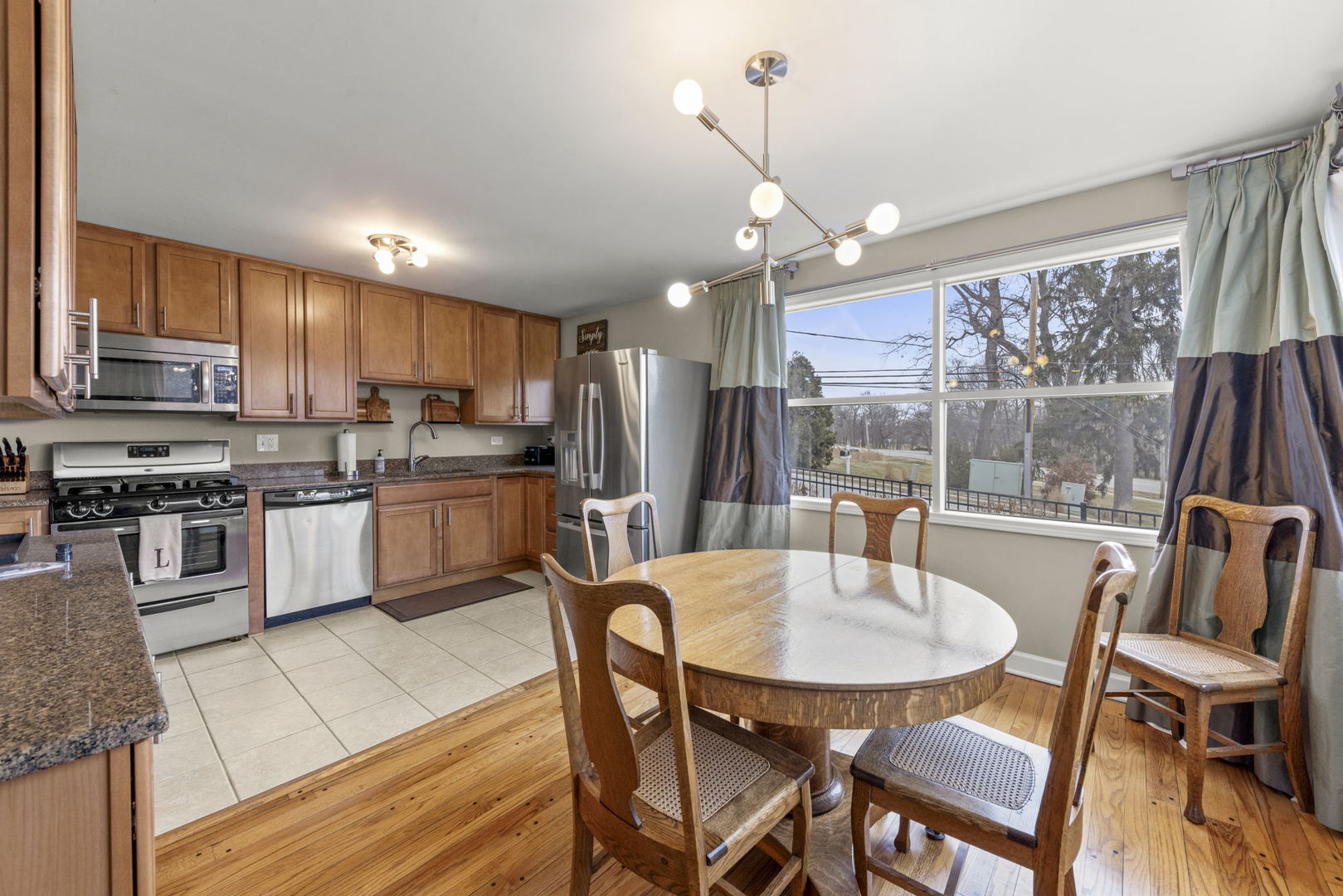 1001 Geneva Road St. Charles, IL 60174 - Photo 4 of 25 a kitchen with stainless steel appliances granite countertop a stove a refrigerator a kitchen island a table and chairs