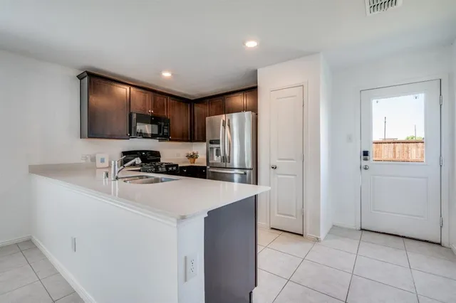 a kitchen with kitchen island a sink stainless steel appliances and cabinets
