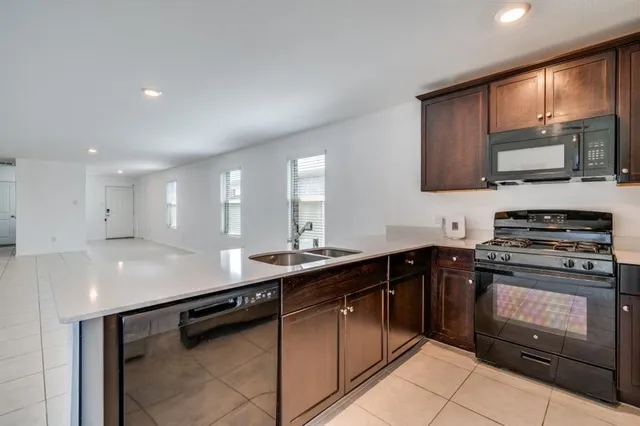 a view of a yard in front of a house with a large tree