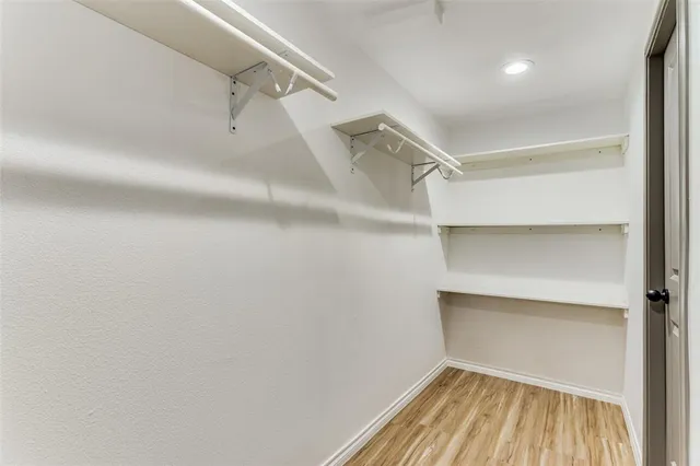 a view of walk in closet with empty racks