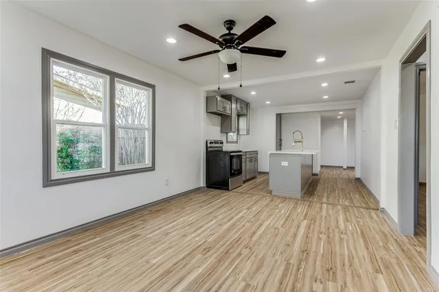 a view of a big room with wooden floor and a window