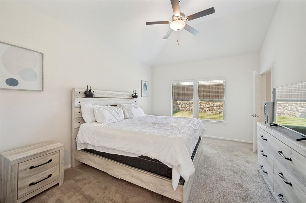 14065 Ilderton Street Pilot Point, TX 76258 - Photo 8 of 19 14065 Ilsderton St., Pilot Point Tx Vaulted ceiling bedroom featuring carpeting, a ceiling fan with integrated lighting, and two windows offering exterior views