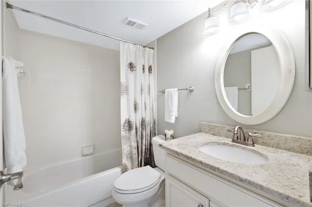 a bathroom with a granite countertop sink a toilet and a mirror