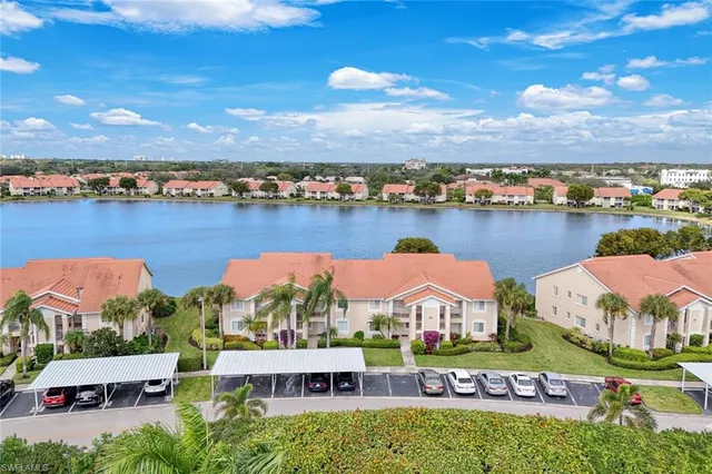 an aerial view of residential houses with outdoor space and lake view