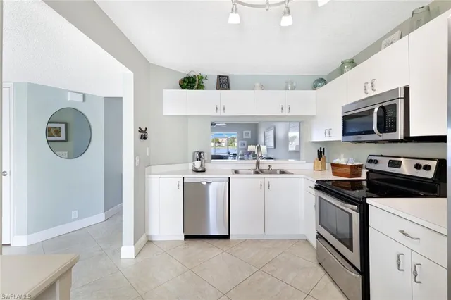 a kitchen with cabinets stainless steel appliances and wooden floor