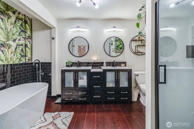 a bathroom with a wooden floor a wall clock and a shower
