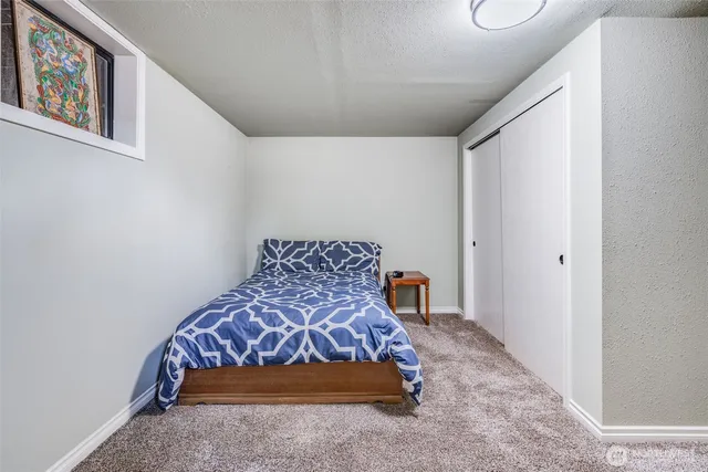 a bedroom with a bed and a painting on the wall