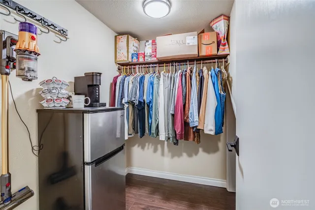 a view of walk in closet with clothes and shoes