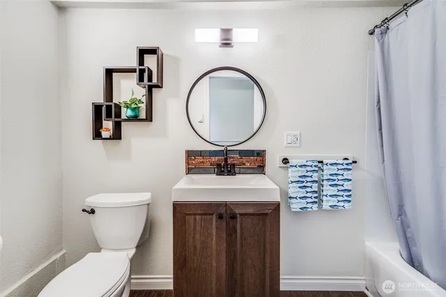a bathroom with a sink a toilet and a mirror