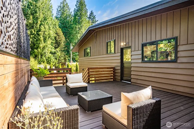 a backyard of a house with wooden floor table and chairs