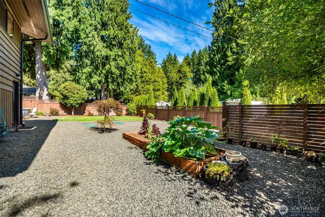 a view of a patio with table and chairs potted plants and large tree