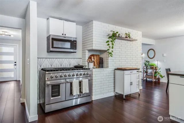 a kitchen with stainless steel appliances a stove microwave and cabinets