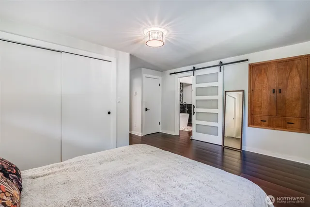 a bedroom with a bed and a closet with wooden floor