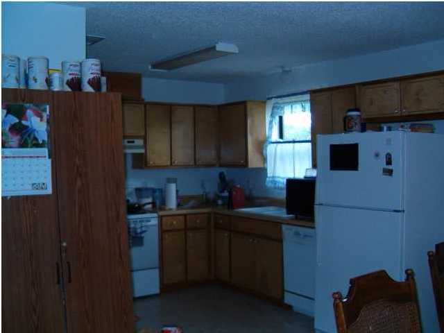 198 Sandy Ramp Road DeFuniak Springs, FL 32433 - Photo 3 of 18 a kitchen with a sink a refrigerator and cabinets