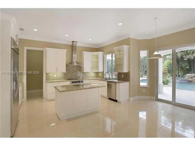a open kitchen with stainless steel appliances kitchen island granite countertop a refrigerator and cabinets