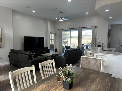 a living room with furniture a flat screen tv and a large window