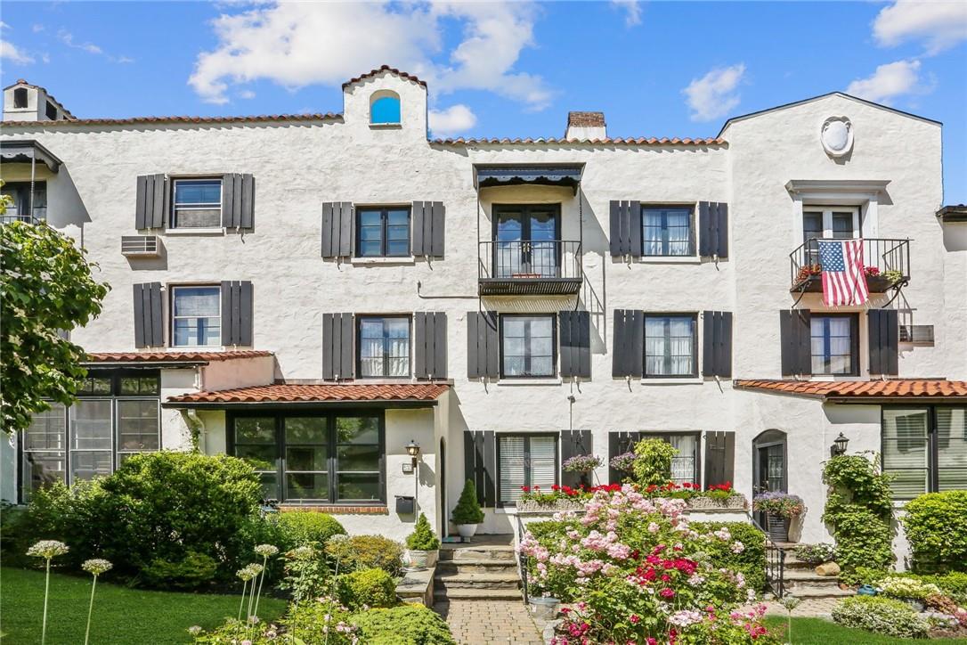 a front view of multi story residential apartment building with a yard