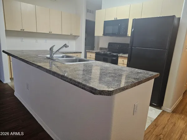 a kitchen with stainless steel appliances granite countertop a sink a refrigerator a washer and dryer