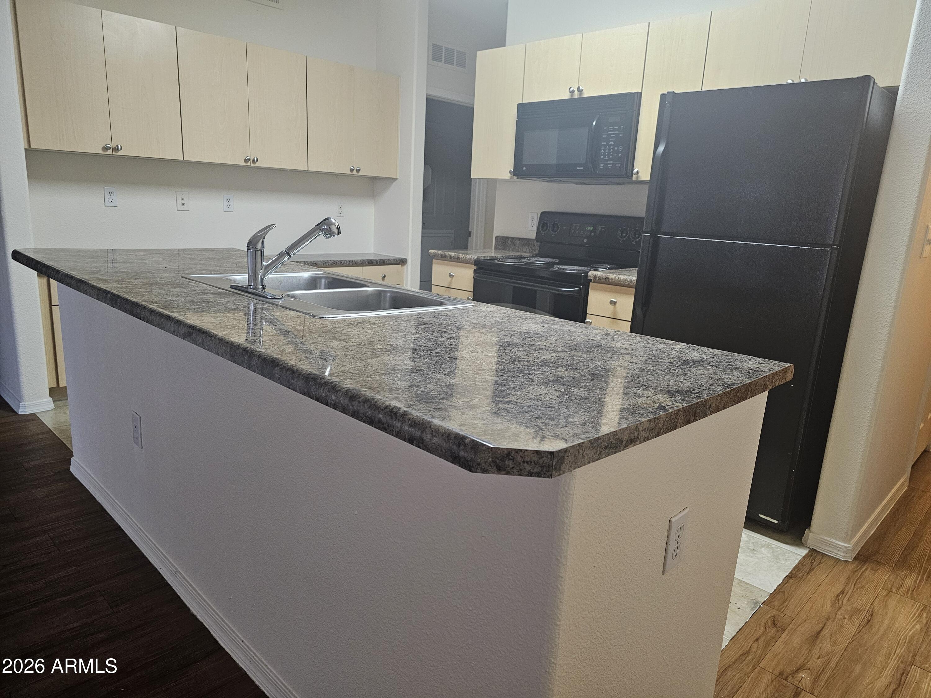 18416 North Cave Creek Road, Unit 1041 Phoenix, AZ 85032 - Photo 3 of 13 a kitchen with stainless steel appliances granite countertop a sink a refrigerator a washer and dryer