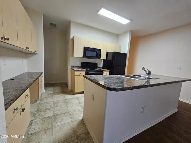 a kitchen with granite countertop a sink and a stove top oven