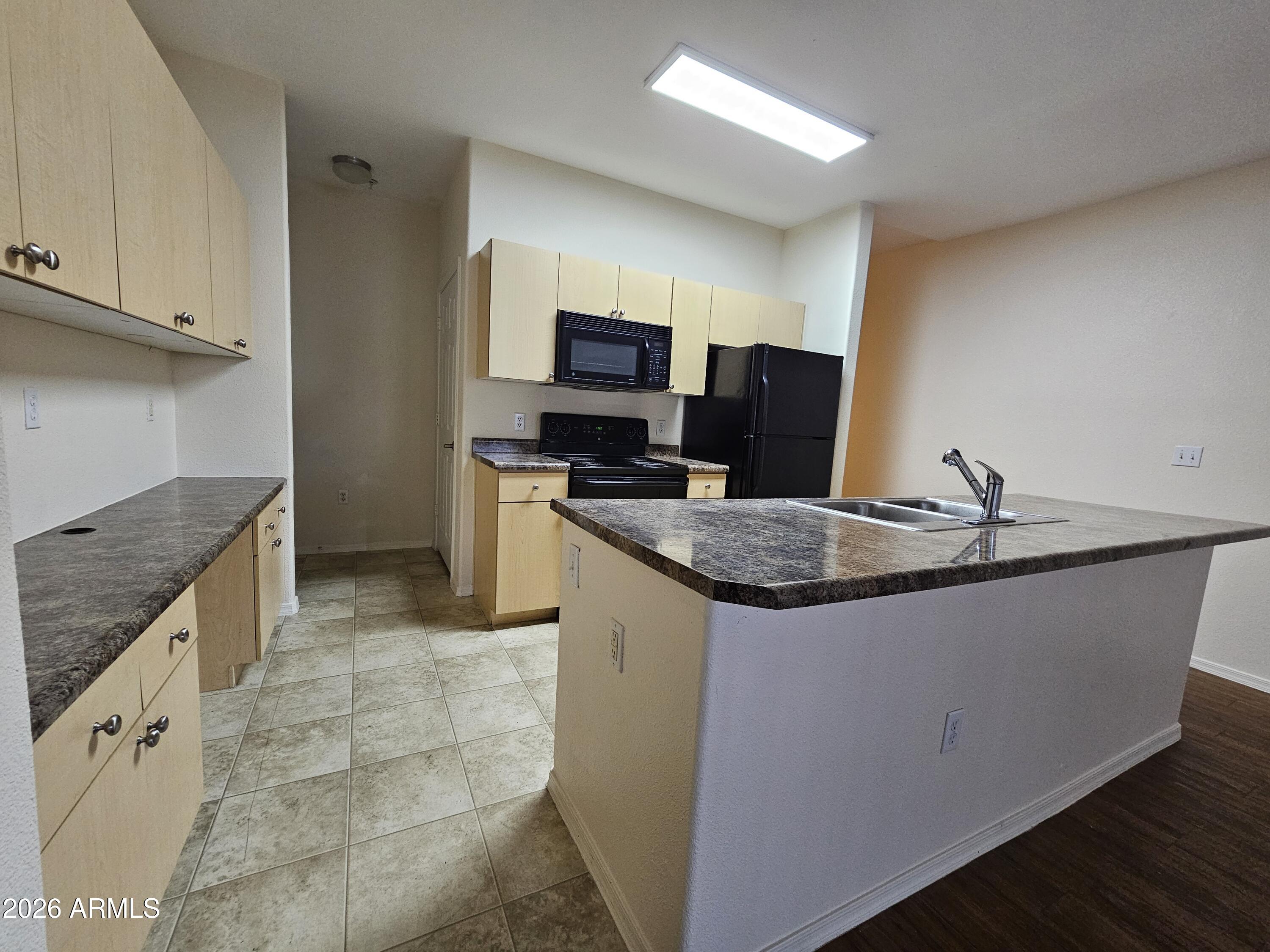 18416 North Cave Creek Road, Unit 1041 Phoenix, AZ 85032 - Photo 4 of 13 a kitchen with granite countertop a sink and a stove top oven