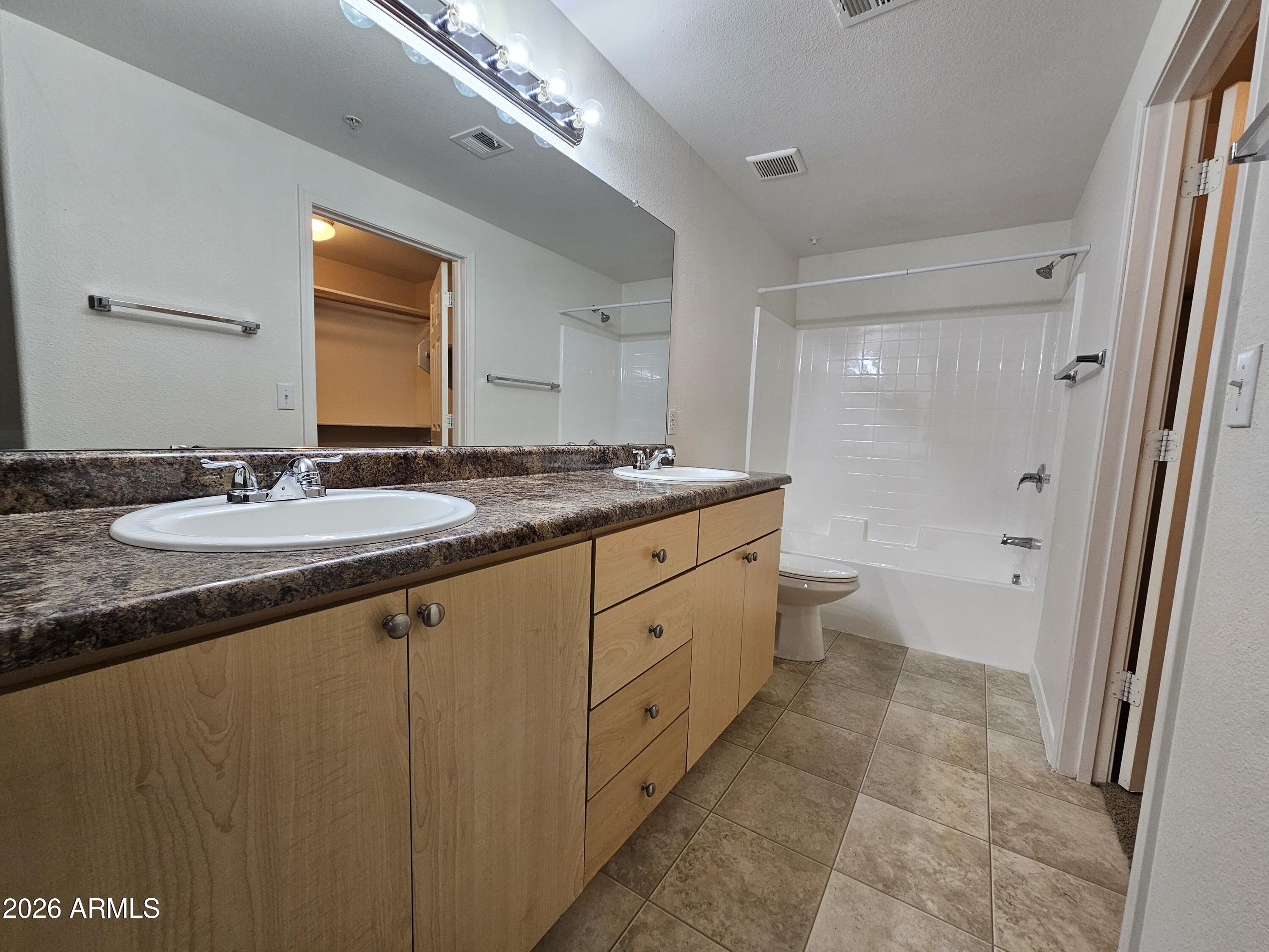 18416 North Cave Creek Road, Unit 1041 Phoenix, AZ 85032 - Photo 7 of 13 a spacious bathroom with a granite countertop sink a mirror and a toilet