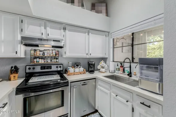 a kitchen with a sink cabinets and a window