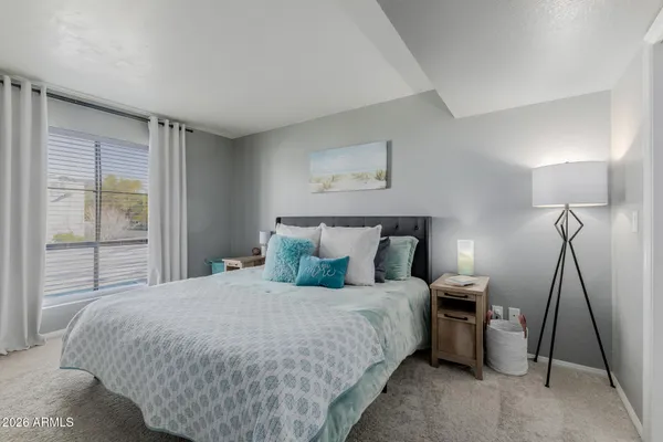 a hotel room with a bed and a flat tv screen on dresser