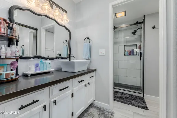 a bedroom with a bed a closet and three windows