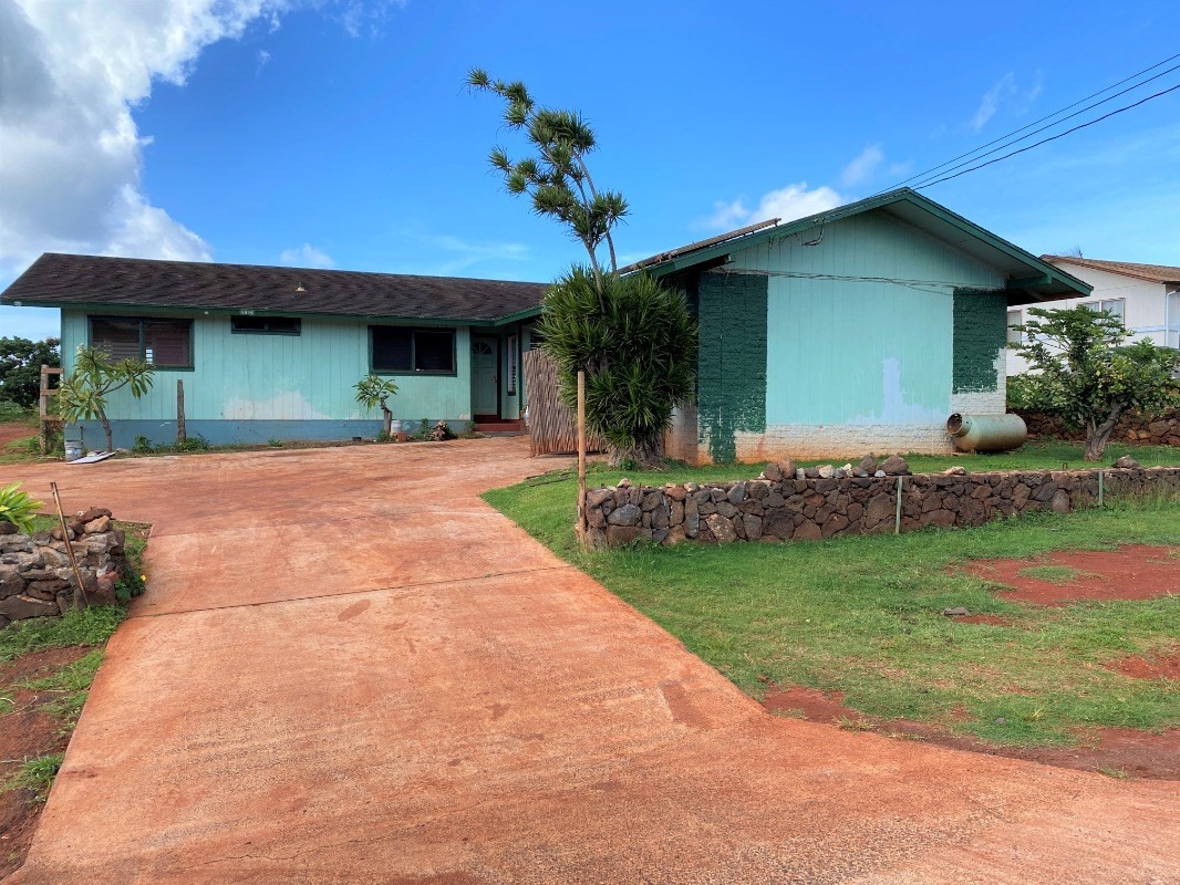 4825 Moi Road Hanapepe, HI 96716 - Photo 1 of 14 a front view of a house with a garden and yard
