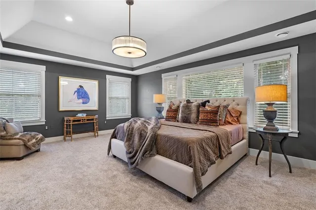 a spacious bedroom with bed and a chandelier