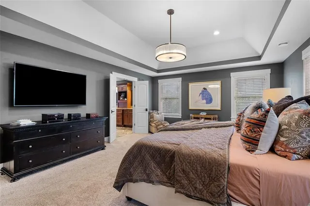 a spacious bedroom with a bed and a flat screen tv