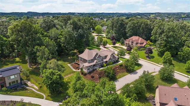 an aerial view of a house with a garden and lake view