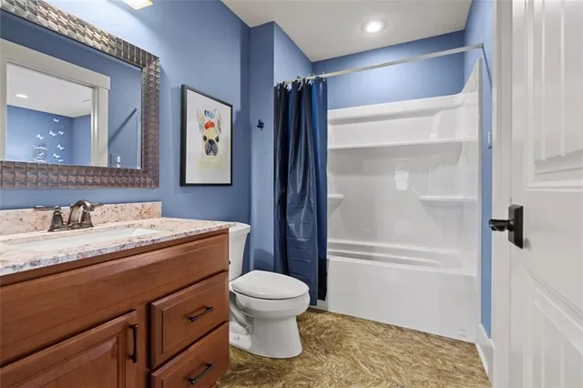 a bathroom with a granite countertop sink toilet and shower
