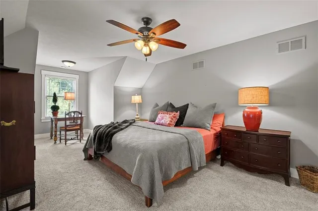 a spacious bedroom with a bed and a chandelier
