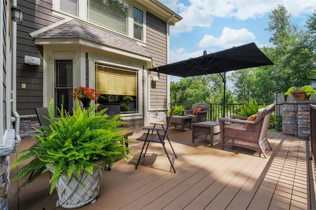 a view of a patio with table and chairs potted plants with wooden floor and fence
