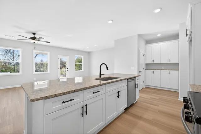 a kitchen with granite countertop white cabinets and white appliances